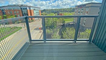 a balcony with a wooden deck and a metal railing